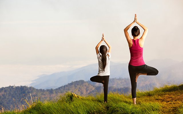 a mom doing yoga with her daughter